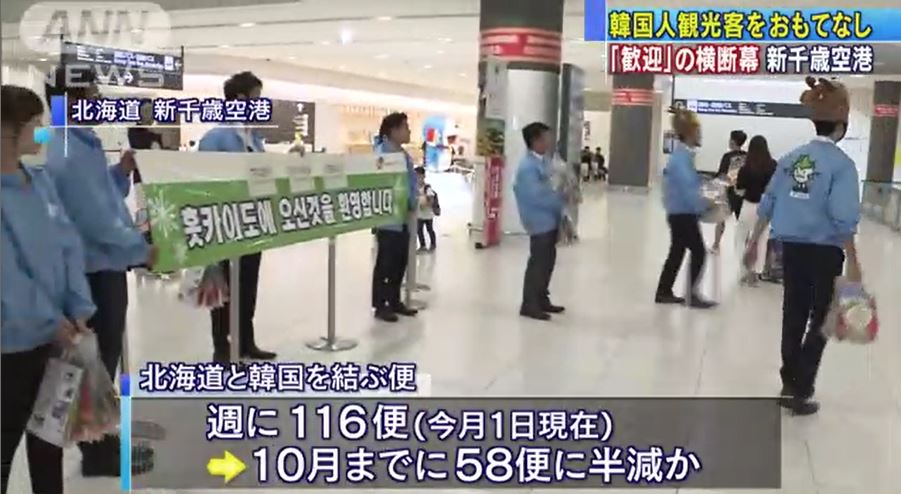 19일 홋카이도 신치토세 공항 입국장에서 한국인 관광객들을 환영하는 행사가 열렸다. 환영 플랜카드를 내걸며 유바리 멜론 젤리가 든 선물꾸러미를 입국하는 관광객들에게 안기고 있다.(이미지: TV아사히화면 캡쳐)