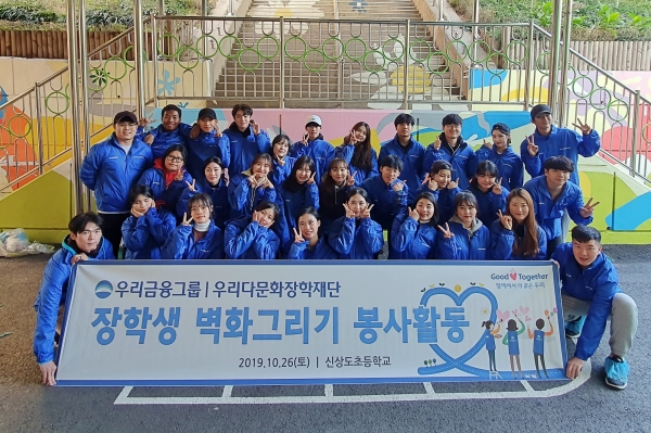우리금융그룹 우리다문화장학재단 대학생 40여명이 서울 신상도초등학교에서 벽화그리기 봉사활동 후 사진촬영을 하고 있다.(우리금융그룹 제공)