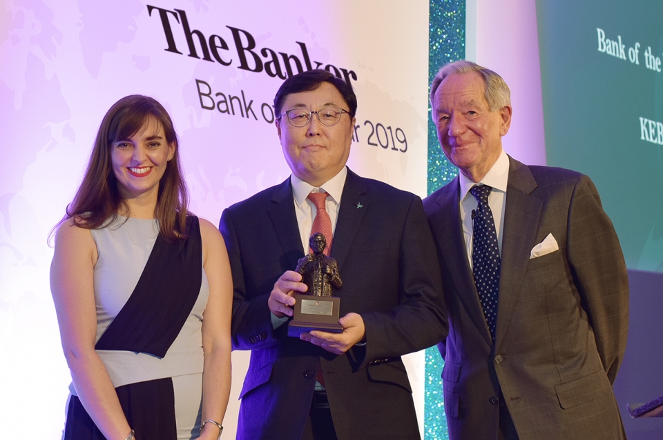 KEB하나은행은 지난 28일(현지 시각) 글로벌 금융전문 매체 더 뱅커(The Banker)지(誌)가 영국 런던 쉐라톤 그랜드 런던 파크 레인 호텔에서 개최한 올해의 은행상(Bank of the Year Awards 2019) 시상식에서 대한민국 최우수 은행상 (Bank of the Year 2019 in Korea)을 수상했다. 박찬범 KEB하나은행 런던지점장(사진 가운데)이 시상식에서 킴벌리 롱 더 뱅커(The Banker)지(誌) 아시아편집장(사진 맨 왼쪽 Kimberly Long, Asia Editor), 마이클 버크 BBC 저널리스트(사진 맨 오른쪽Michael Buerk, Broadcast Journalist BBC)와 함께 기념촬영을 하고 있다.(KEB하나은행 제공)
