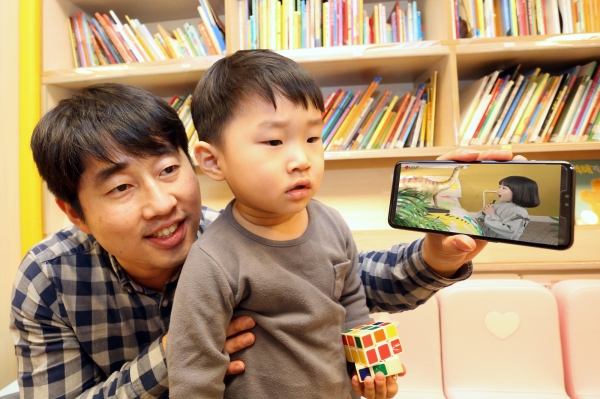 LG유플러스는 어린이들이 선호하는 동화, 자연관찰, 과학 등의 콘텐츠를 3D AR로 생동감있게 즐길 수 있는 모바일 교육 애플리케이션 ‘U+아이들생생도서관’을 17일 출시한다고 밝혔다. 사진은 자녀와 부모고객이 U+아이들생생도서관을 이용하고 있는 모습. (LG유플러스 제공)