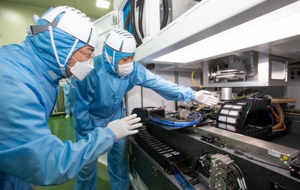 삼성전자 직원(왼쪽)과 이오테크닉스 직원(오른쪽)이 양사가 공동 개발한 반도체 레이저 설비를 함께 살펴보고 있다.(사진=삼성전자)